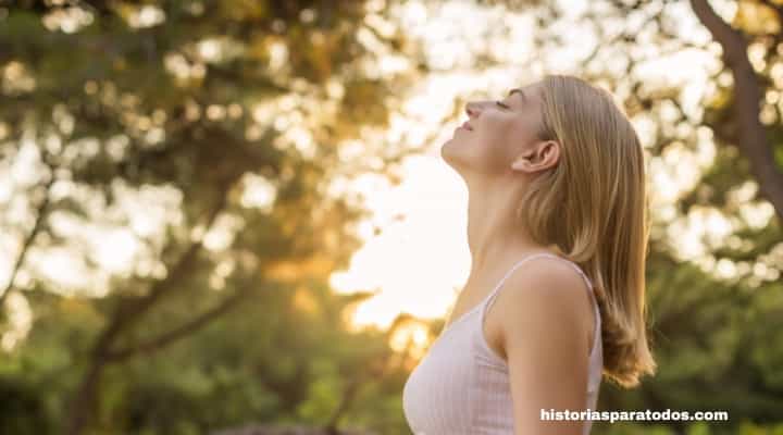 Mujer practicando respiración consciente en la naturaleza, ejercicio recomendado en Sorprende a tu cerebro reseña para reducir el estrés